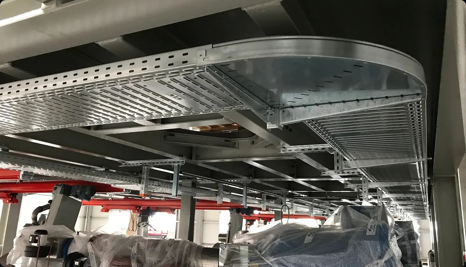 Bogen einer Kabeltrasse unter der Decke einer Industriehalle