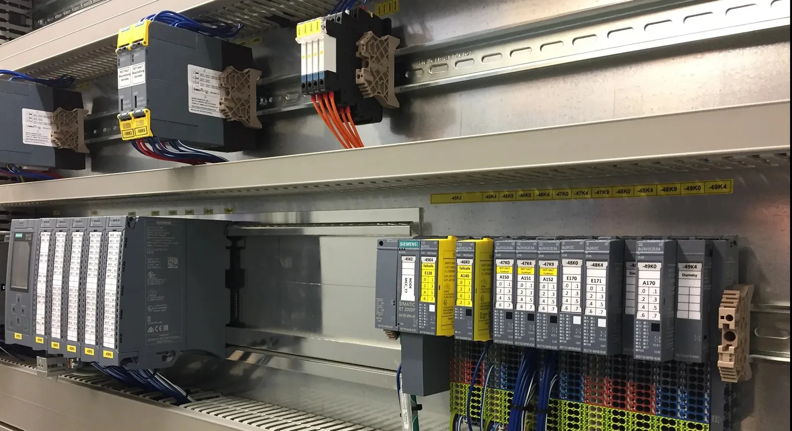 Siemens Baugruppen und Sicherheitsrelais auf Hutschienen in einem Schaltschrank