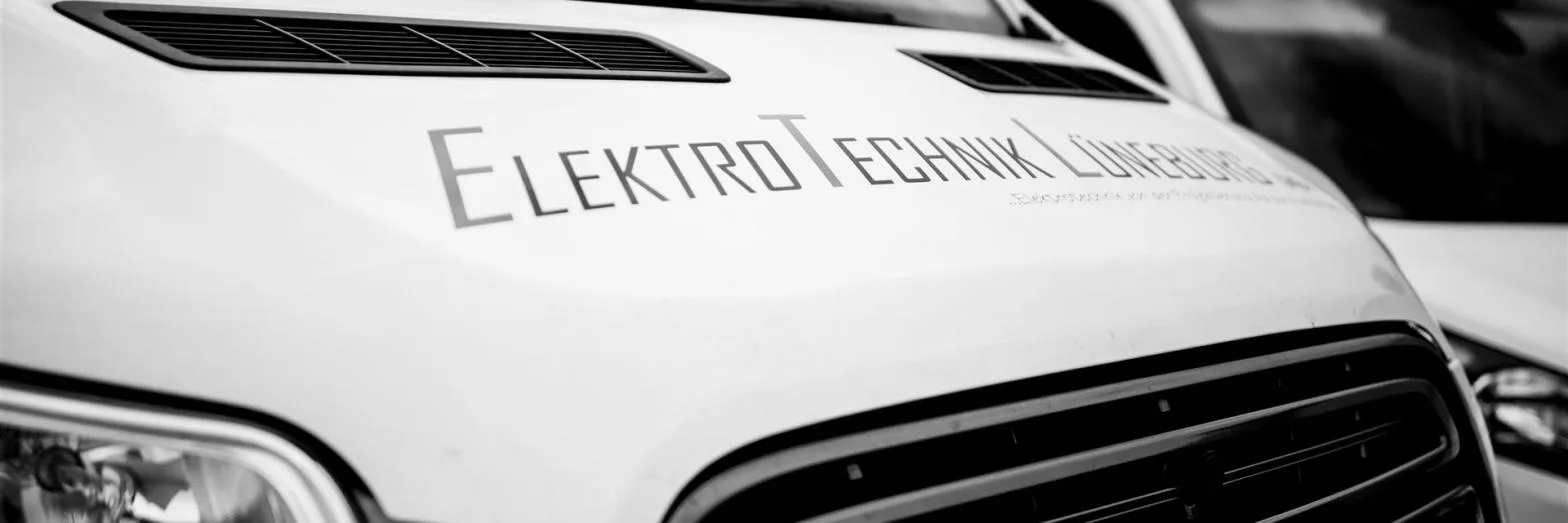 Motorhaube eines Firmenwagens mit dem Schriftzug ElektroTechnik Lüneburg, schwarzweiß