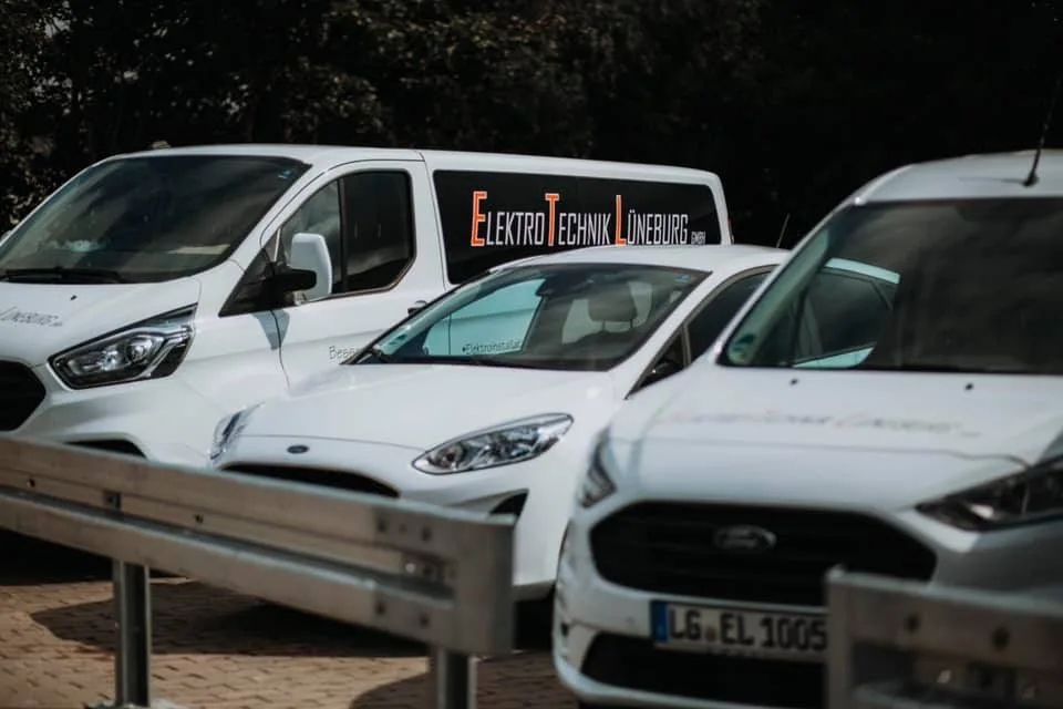 Drei weiße Firmenwagen, einer mit dem Schriftzug ElektroTechnik Lüneburg